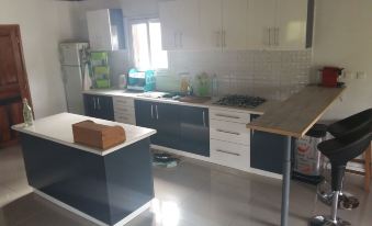 a modern kitchen with white cabinets and black countertops , featuring a large island in the center at The Sanctuary