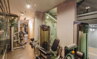 a well - equipped gym with various exercise equipment , including treadmills and weightlifting machines , in a spacious room at Slive Hotel