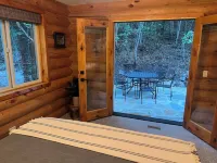 Cozy log cabin secluded in a mountain forest with hot tub, sauna, private patio.