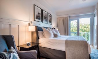 a bedroom with a large bed , a chair , and two lamps on either side of the bed at WaterSound Inn