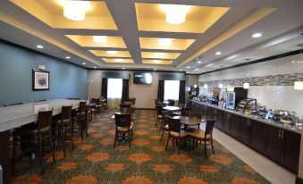 a large dining area with multiple tables and chairs , as well as a buffet table at Best Western Plus Williston Hotel  Suites