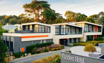 "a modern hotel building with orange accents and the sign "" findeck hotel "" in front" at Flinders Hotel