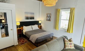 a cozy bedroom with a bed , couch , and lamp , as well as a living room area with a couch and lamp at The Lincoln Marfa