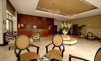 a large , well - lit hotel lobby with a reception desk , comfortable seating area , and crystal chandeliers at The Parkview Hotel