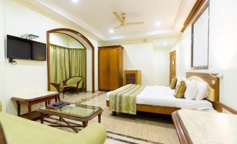 a large bedroom with a king - sized bed , a flat - screen tv mounted on the wall , and a chair in the corner at Garden Hotel