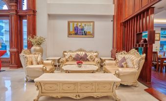 a luxurious living room with gold and white furniture , including a couch , chairs , and a coffee table at Lbn Asian Hotel