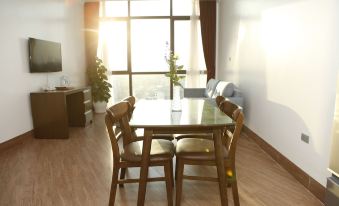 a dining table with wooden chairs is placed in a room with a window and hardwood floors at Binh Minh Hotel