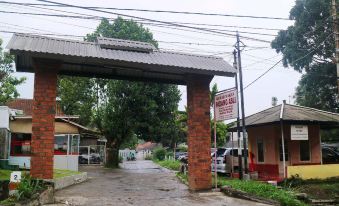 a brick archway with a sign on it , located in front of an apartment building at Mason Residence Syariah Ciawi