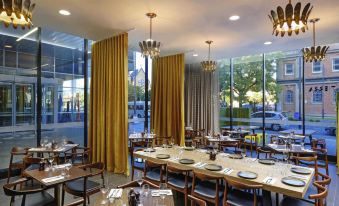 a large , well - lit restaurant with multiple dining tables and chairs arranged in an open space at Mantra Albury Hotel