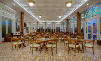 a large dining room with wooden tables and chairs arranged in a symmetrical fashion , creating an elegant and cozy atmosphere at Ramada Suites by Wyndham Solo