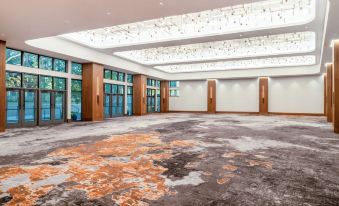 a large , empty conference room with a carpeted floor and multiple windows , set against a backdrop of wooden walls and ceiling at Hilton Dallas Lincoln Centre