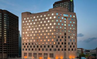 a tall building with many windows and a large sign on top , surrounded by other buildings in the city at Doubletree by Hilton Montreal