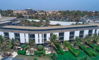 an aerial view of a city with palm trees and a large building in the background at Radisson Blu Hotel, Dakar Sea Plaza