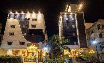 a night view of a hotel with a large palm tree and multiple buildings in the background at Hotel Celebration