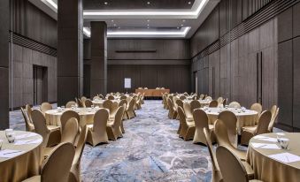 a large dining room with many tables and chairs , all set up for a formal event at Mercure Tangerang BSD City