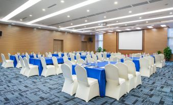 A spacious event room is prepared with tables and chairs, ready for use at Holiday Inn Express Chengdu West Gate