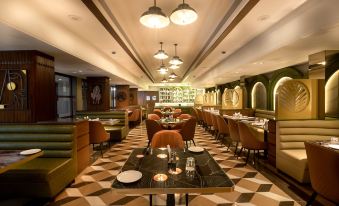 a restaurant with wooden tables and chairs , green and white checkered flooring , and hanging light fixtures at Freesia by Express Inn