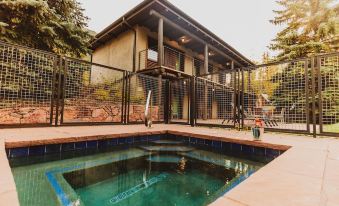 a wooden house with a hot tub and a swing set in the backyard , surrounded by trees at Little Beaver Inn