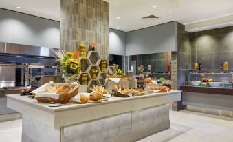 a modern restaurant interior with a buffet table filled with various food items and utensils at Crowne Plaza Dublin - Blanchardstown