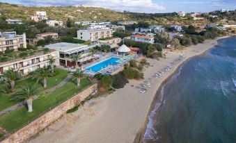 an aerial view of a resort with a pool , beach , and ocean in the background at Golden Sand Hotel