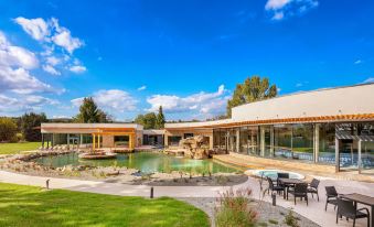 a large , modern house with a swimming pool and patio area , surrounded by trees and grass at Hotel Atlantis