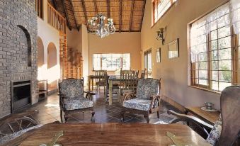 a dining room with a wooden table and chairs , a chandelier hanging from the ceiling , and a chandelier hanging above at The Cottage