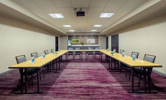 a conference room with long tables and chairs arranged in a semicircle , providing seating for a group of people at Courtyard Dayton North