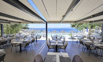 an outdoor dining area at a restaurant , with tables and chairs arranged for guests to enjoy their meal at Agali Hotel Paxos
