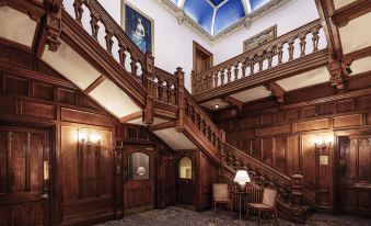 a grand staircase with wooden railings and walls , leading up to the second floor of a building at Mercure Bradford Bankfield Hotel