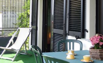 a cozy outdoor dining area with blue furniture , green flooring , and white shutters , under a clear sky at Bellavista