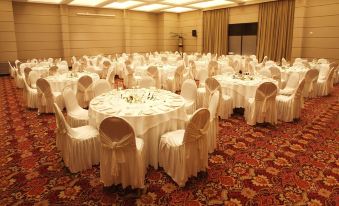 a large dining room with round tables covered in white tablecloths and chairs arranged around them at DiplomaticHotel