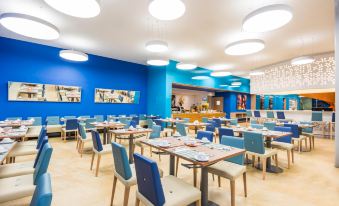 a large dining room with multiple tables and chairs arranged for a group of people at Cosmos Pacifico Hotel