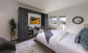 a spacious bedroom with a king - sized bed , a dresser , and a tv mounted on the wall at Wine Stone Inn