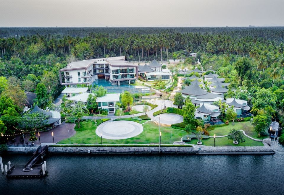 a bird 's eye view of a resort with multiple buildings and a large body of water at Na Tree Tara Riverside Resort Amphawa Damnoensaduak