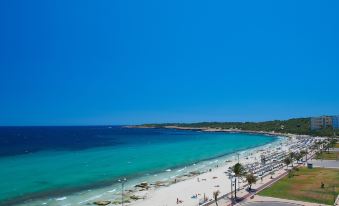 a beautiful beach scene with a group of people enjoying their time on the sand and in the water at Hipotels Flamenco