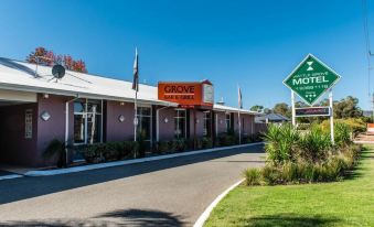 a modern building with a sign for grove hotel , and a green street sign indicating the location at Wattle Grove Motel