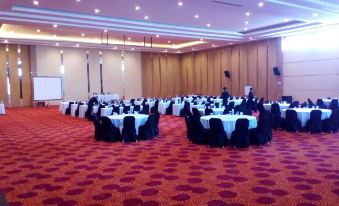 a large banquet hall filled with round tables and chairs , ready for a formal event at Novena Hotel Bandung