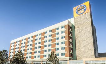 a large hotel with a yellow and brown sign on the side , located in a city setting at Akwesasne Mohawk Casino Resort and Players Inn Hotel -Formerly Comfort Inn and Suites Hogansburg NY