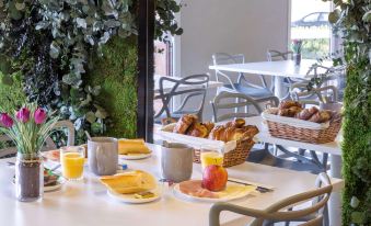 a dining table with a variety of food items , including croissants , fruit , and other dishes at Sure Hotel by Best Western St-Amand-Les-Eaux