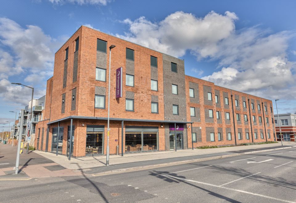 a brick building with multiple floors , a large window display , and a sign on the side at Premier Inn Hereford City Centre (Old Market)
