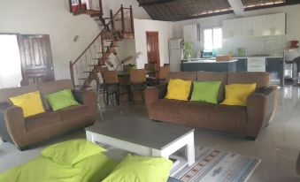 a spacious living room with two couches , a dining table , and a staircase leading to the second floor at The Sanctuary