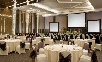 a large banquet hall with round tables and chairs set up for a formal event at Novotel Bangka - Hotel & Convention Centre