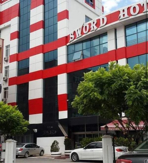 "a red and black striped building with the words "" sword hotel "" prominently displayed on it" at Sword Hotel