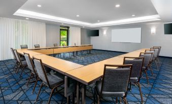 a large conference room with multiple rows of chairs arranged in a semicircle around a long table at Courtyard Danbury