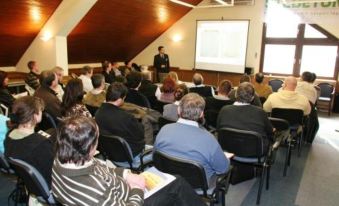 a man is giving a presentation to a group of people in a conference room at Waterfront