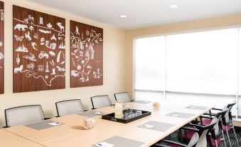a conference room with a long wooden table , chairs , and artwork on the wall , set up for a meeting at TownePlace Suites Memphis Southaven