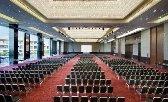 a large conference room with rows of chairs arranged in a symmetrical fashion , and a podium at the front at Dusit Thani LakeView Cairo