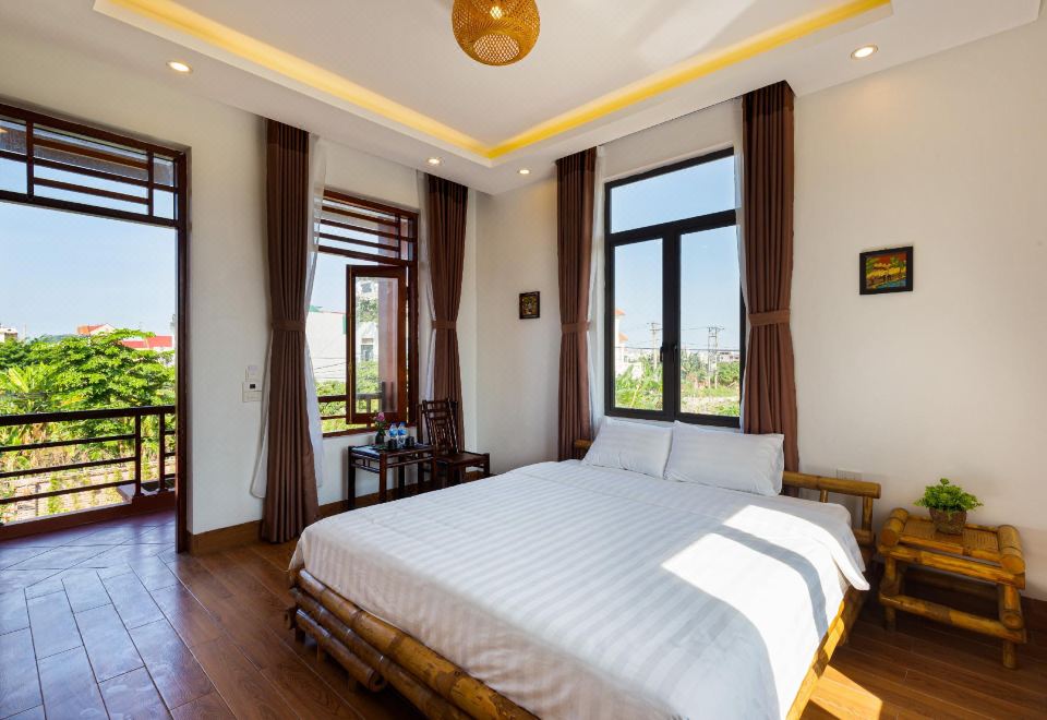 a spacious bedroom with a king - sized bed , hardwood floors , and large windows overlooking a balcony at MH Cherish Homestay