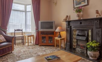 a cozy living room with a fireplace , a tv on the wall , and various furniture such as a dining table , chairs , and a at The Waterfront