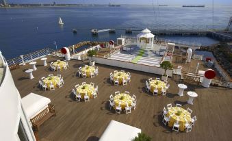 a large outdoor dining area with multiple tables and chairs set up for a party or event at The Queen Mary